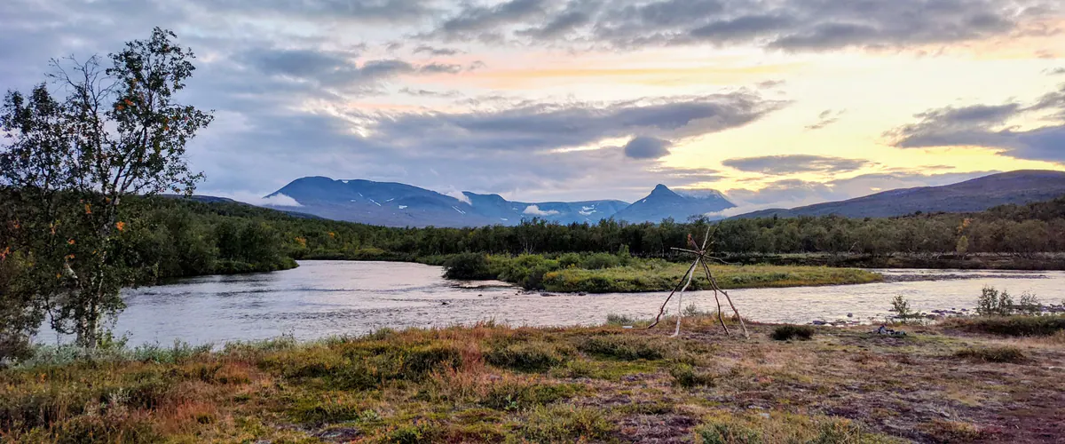 Fly fisher on a rocky river bank under a big sky
