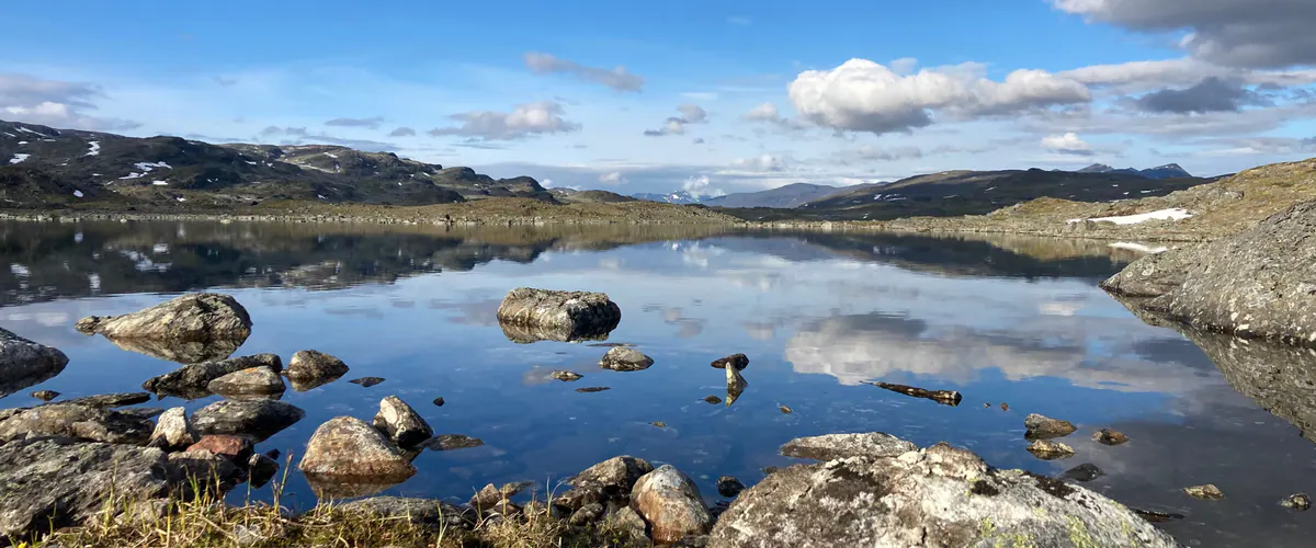 Calm fell lake with mountains mirrored in the water