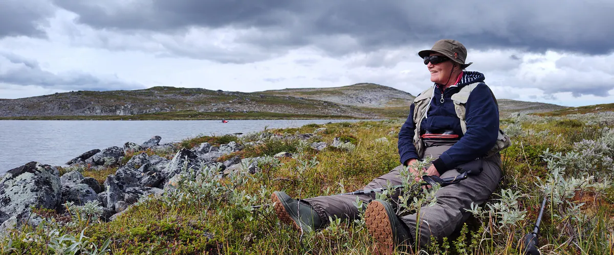 Guide resting on a fell with fishing gear