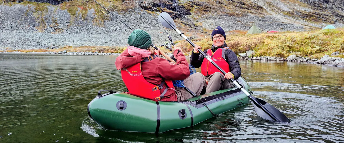 Two anglers paddling a green packraft
