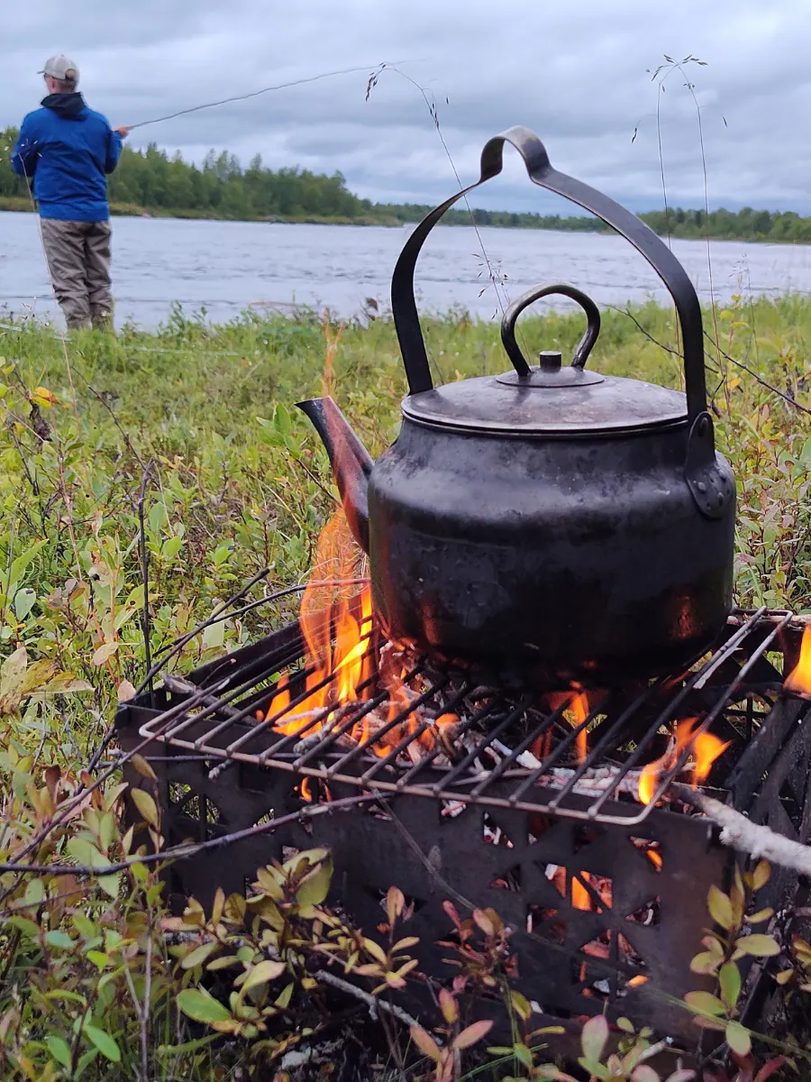 Coffee kettle over a campfire by the river