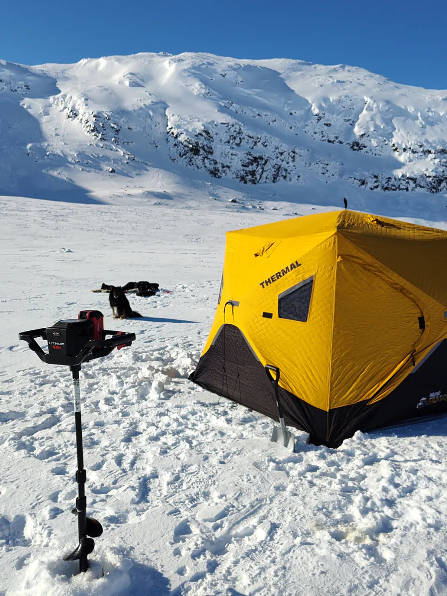 Ice fishing tent and auger on a frozen lake