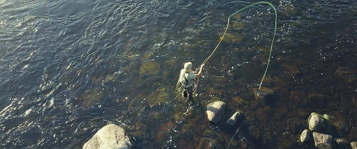 Aerial view of a fly fisher in a clear Lapland river