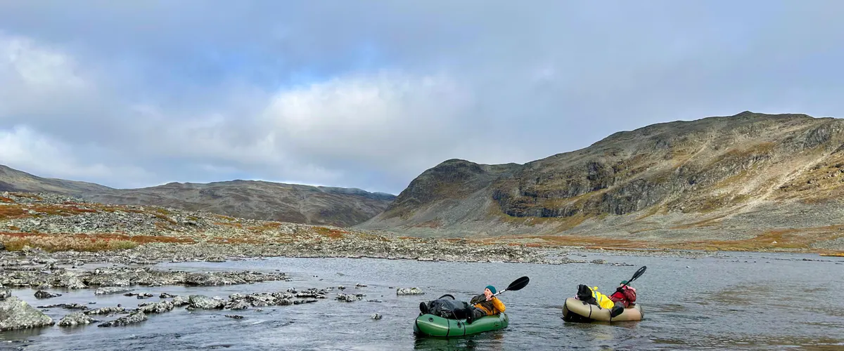 Packrafts on a stony river shore below the fells