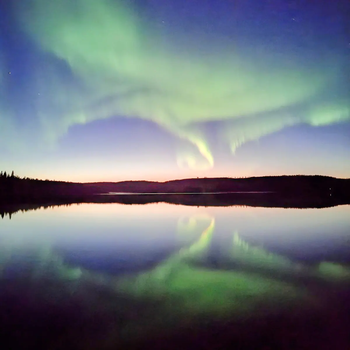 Northern lights over a calm lake