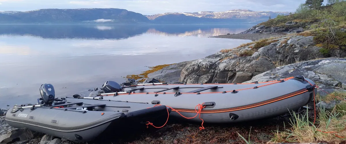 Rubber boat pulled up on a fjord beach