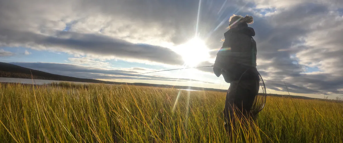 Angler on a sunlit fell meadow