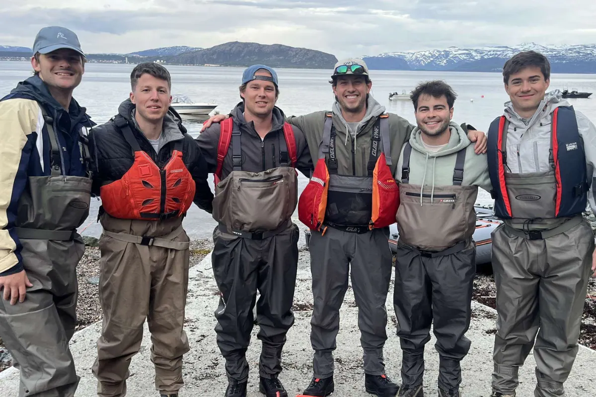 Group of anglers in waders by a lake