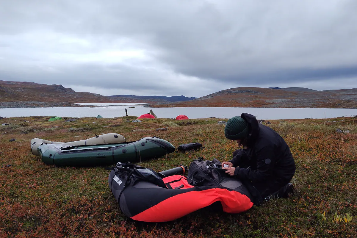Packrafts and waders on the shore of a mountain lake