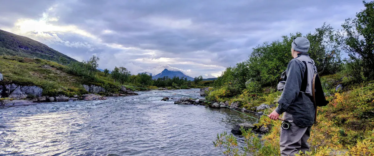 Angler watching a fast river in summer