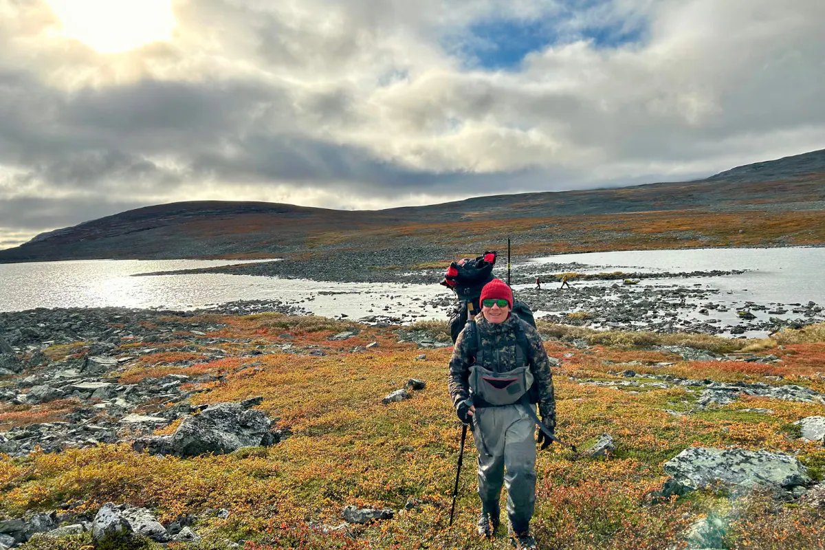 Angler hiking across the fells to a remote lake