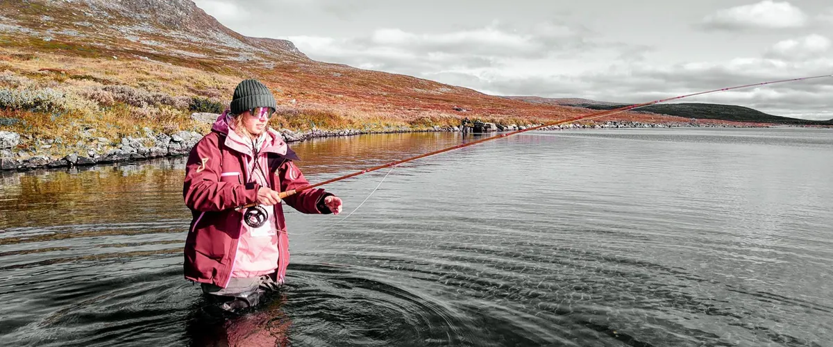 Angler fishing a lake in autumn colours